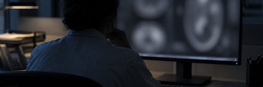 AI generated illustration of a radiologist reviewing a blurred grayscale display in a reading room