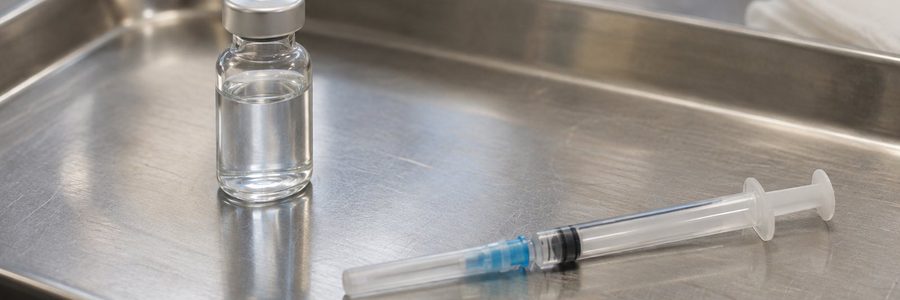 AI generated illustration of an unlabeled vial and capped syringe on a clinical tray
